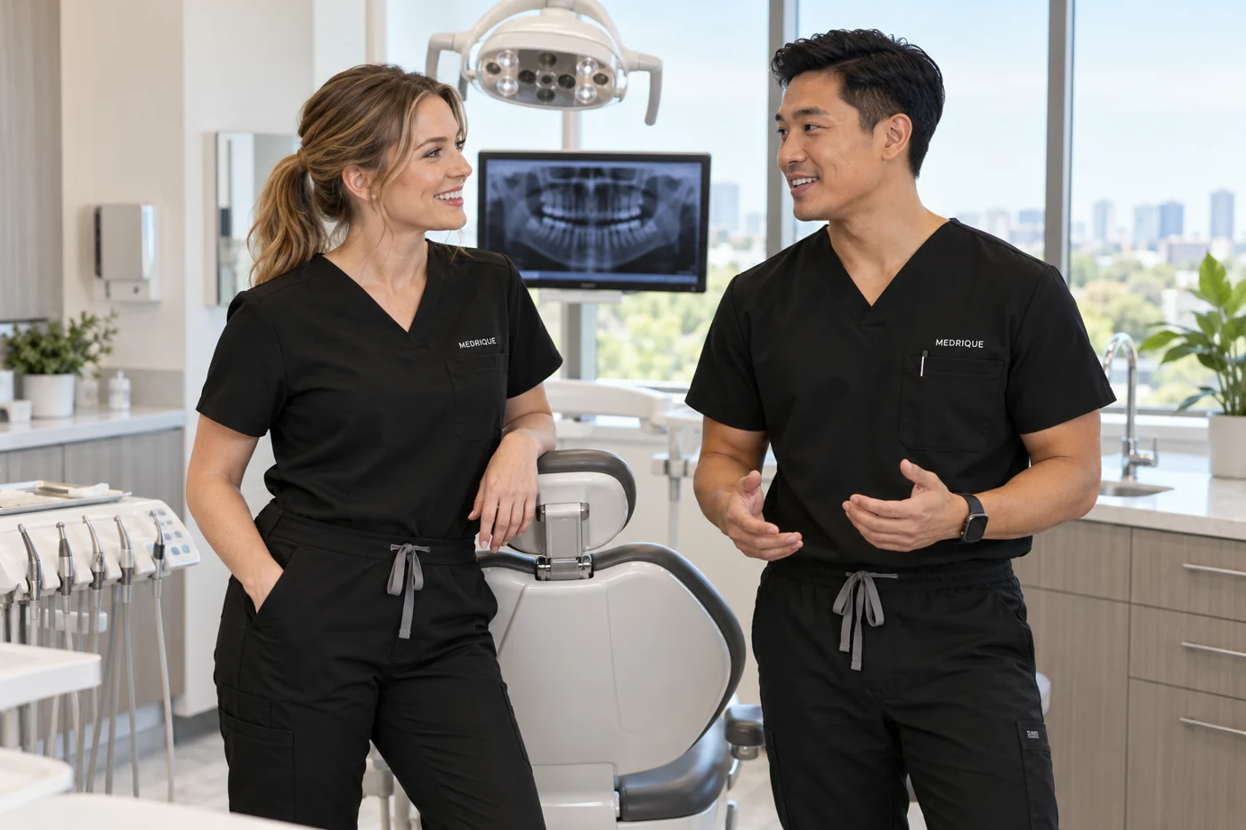 Dental professionals wearing black scrubs in a treatment room