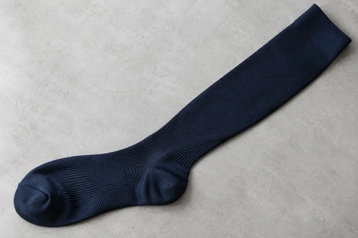 Navy knee-high scrub sock showing ankle and calf knit construction